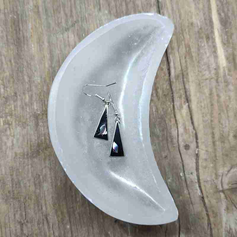 Black triangle earrings with shell, in a bowl