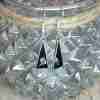 Black triangle earrings with shell, on a jar